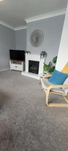 sala de estar con silla y chimenea en Rent Unique the Beeches 2bed, en Crawley