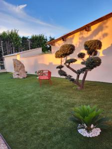 - un jardin avec un banc rouge dans la cour dans l'établissement Pissenlit Une Prairie en Provence, à Arles