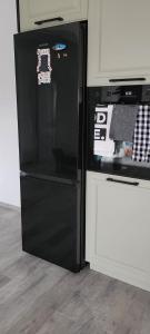 a black refrigerator with stickers on it in a kitchen at Rental house in Dumbrăviţa