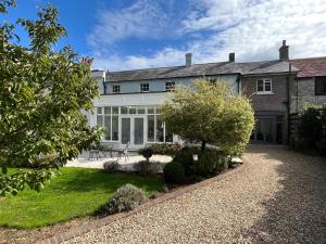 a large white house with a garden in front of it at Stunning and luxurious Manor House holiday home in Broadmayne