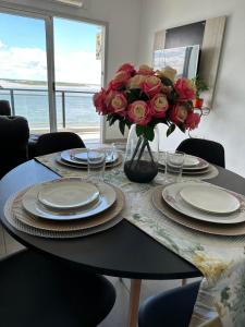 a table with plates and a vase of flowers on it at Departamento en Corrientes in Corrientes +8 photos