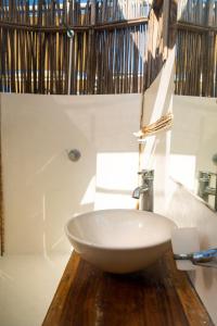 uma casa de banho com um lavatório branco num balcão de madeira em NENA BEACH CLUB & HOTEL em Barú
