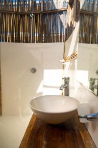 a bathroom with a white sink on a wooden counter at NENA BEACH CLUB & HOTEL in Baru +61 photos
