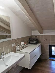 a bathroom with a white sink and a fireplace at Agriturismo Dai Marchesin in Nasino