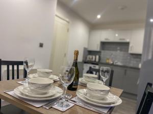 a table with plates and glasses and a bottle of wine at Urban Retreat - Bradford Apartment Gem in Bradford