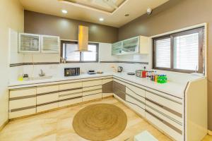 a kitchen with white cabinets and a wooden floor at Coliwo Deux - Chandan Nagar in Pune