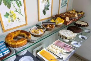 a display case with different types of bread and pastries at Pousada Boulevard in Cabo Frio
