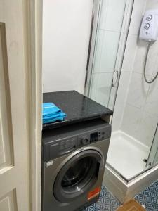 een wasmachine in een badkamer naast een douche bij Ground floor One Bedroom Flat Hyde Park In Central London in Londen