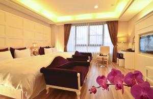 a bedroom with a large bed with purple flowers on the floor at Hotel Modern Puli in Puli