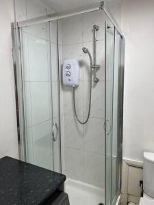 een douche met een glazen deur in de badkamer bij Ground floor One Bedroom Flat Hyde Park In Central London in Londen