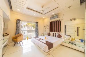 a bedroom with a large bed and a chair at Coliwo Deux - Chandan Nagar in Pune