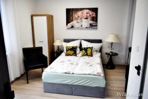 1 dormitorio con 1 cama y 1 silla negra en Willa Adler Ustroń - Spokojna okolica, Blisko cntrum, en Ustroń