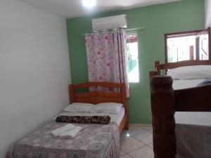 a small bedroom with two beds and a window at Suítes Xodo Tour in Arraial do Cabo +36 photos
