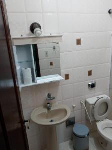 a small bathroom with a sink and a toilet at Suítes Xodo Tour in Arraial do Cabo +29 photos