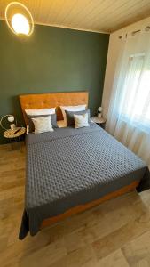 um quarto com uma cama grande e um edredão azul em Apartments San em Sukošan