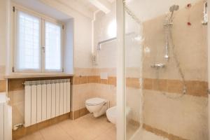 a bathroom with a toilet and a glass shower at Ca' Del Jago Sole Luna apartment in Negrar