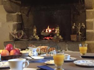 stół z jedzeniem i napojami oraz kominek w obiekcie Le Domaine de Belleville w mieście Dragey
