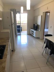 a kitchen with a refrigerator and a table and chairs at Cumbuco Residence - Beach in Cumbuco
