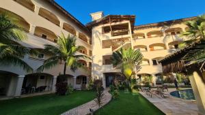 an exterior view of a building with palm trees at Cumbuco Residence - Beach in Cumbuco