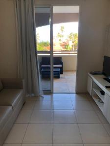 a living room with a couch and a window at Cumbuco Residence - Beach in Cumbuco