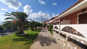 a sidewalk next to a building with a palm tree at Saint George's Hotel in Nea Stira