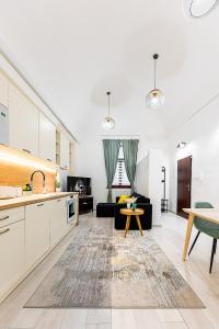 Center Apartment Mlynska Kosice with private Parking في كوشيتسه: مطبخ وغرفة معيشة مع أريكة وطاولة