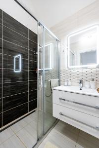 a bathroom with a glass shower and a sink at Center Apartment Mlynska Kosice with private Parking in Košice