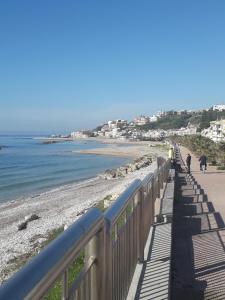 una pasarela a lo largo de una playa con gente paseando a sus perros en Casa del Corso Ribera, en Ribera