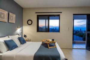 a bedroom with a large white bed with a table on it at Jo Marinis Rooms in Korinthos