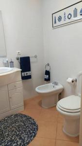 a white bathroom with a toilet and a sink at Apartamento em Torreira - Nenúfares in Torreira