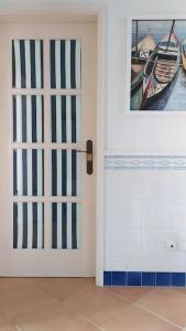 Apartamento em Torreira - Nenúfares في توريرا: باب في غرفة مع صورة قارب