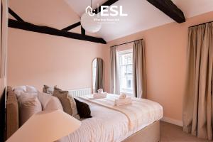 a bedroom with a bed and a window at Elegant Apartment on Historic Cobbled High St Shrewsbury Town Centre in Shrewsbury