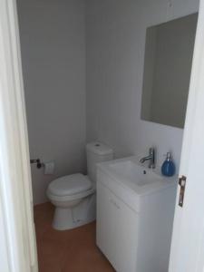 a white bathroom with a toilet and a sink at Apartamento em Torreira - Nenúfares in Torreira