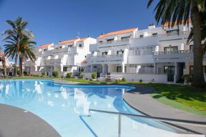 una grande piscina di fronte a un edificio di Apartamentos Los Rosales a Los Cancajos