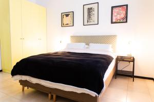 um quarto com uma cama grande e um cobertor preto em House in Shalma em Tel Aviv