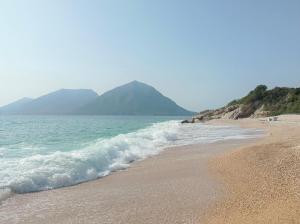 a beach with the ocean and mountains in the background at Asteri Apartments Mytikas 2-Bedroom Seaview Courtyard in Mitika