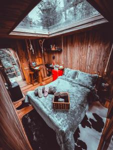 a bedroom with a large bed in a log cabin at Cabana da Árvore - ForestPlace in Monte Verde