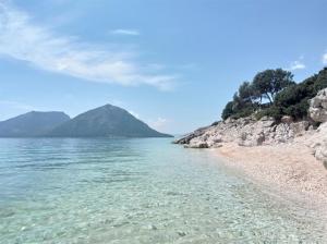 a view of the beach with mountains in the background at Asteri Apartments Mytikas 2-Bedroom Seaview Courtyard in Mitika