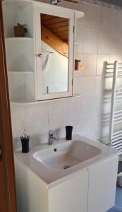 um lavatório branco na casa de banho com um espelho em Charming 2.5Room Flat in Center of Monforte d'Alba em Monforte dʼAlba