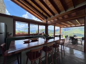 une cuisine avec une grande table et des chaises en bois dans l'établissement Refúgio Morro Alto, à Delfinópolis