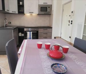 una cucina con tavolo rosa e teiera rossa di La Casa di David a Como