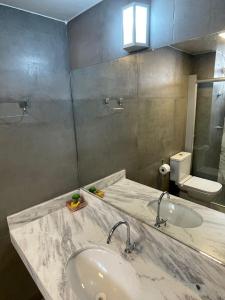 a bathroom with a sink and a mirror at Apartamento aconchegante 1911 in Goiânia