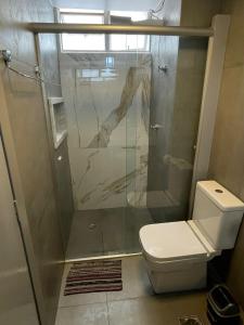 a bathroom with a toilet and a glass shower at Apartamento aconchegante 1911 in Goiânia