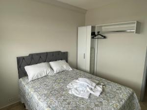 a bedroom with a bed with a robe on it at Apartamento aconchegante 1911 in Goiânia
