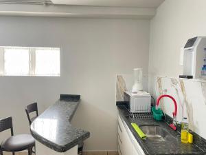 a kitchen with a sink and a counter top at Apartamento aconchegante 1911 in Goiânia