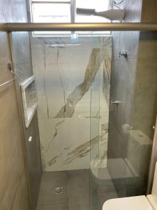 a bathroom with a shower with a glass door at Apartamento aconchegante 1911 in Goiânia