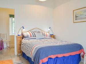 a bedroom with a bed with a striped bedspread at Cliff Cottage - Uk43207 in Dale