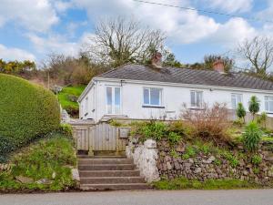 a white house with stairs and a stone wall at Cliff Cottage - Uk43207 in Dale