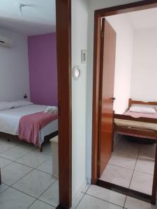 Habitación con 2 camas y puerta con espejo. en Ramos Acomodações, en Búzios