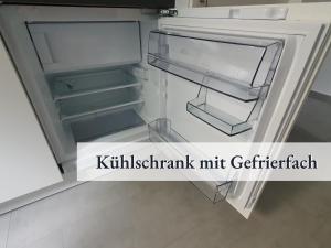 lodówka z otwartymi drzwiami z wyrazami współczynnika mikrofonu kitzkritaminy w obiekcie Apartment_BaLi w mieście Linkenheim-Hochstetten